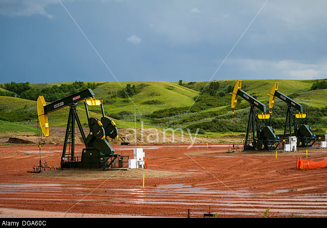 Oil pumpers in the Bakken shale oil fields in rolling hills of North Dakota Photo Credit (c) America Alamy